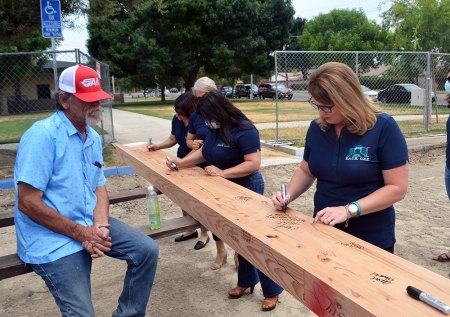 Superintendent Cheryl Hunt signs a cross beam to be used in the new schools administration building. 